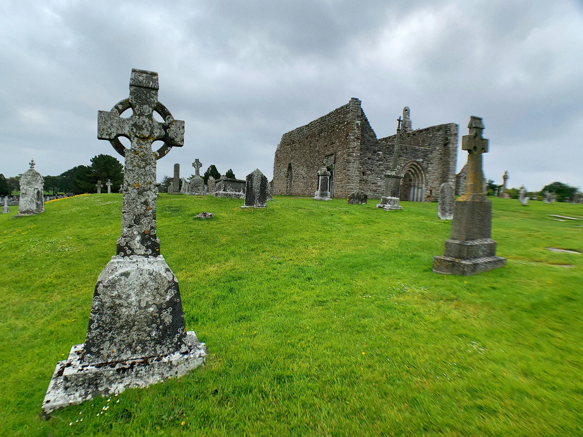 Church ruins and stone crosses beneath a cloudy sky; an illustrative historical landscape.